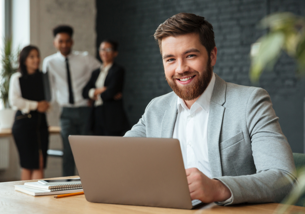 Executive man working on his laptop in a modern and diverse office environment