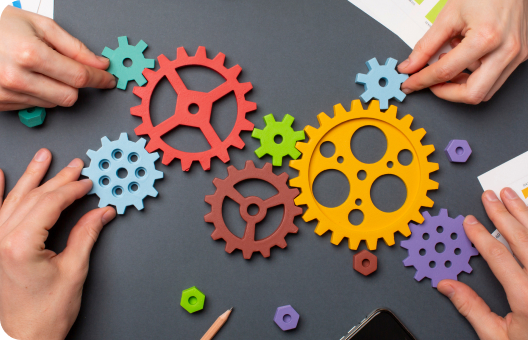 A group of people working with gears on a table, symbolizing strategic recruitment