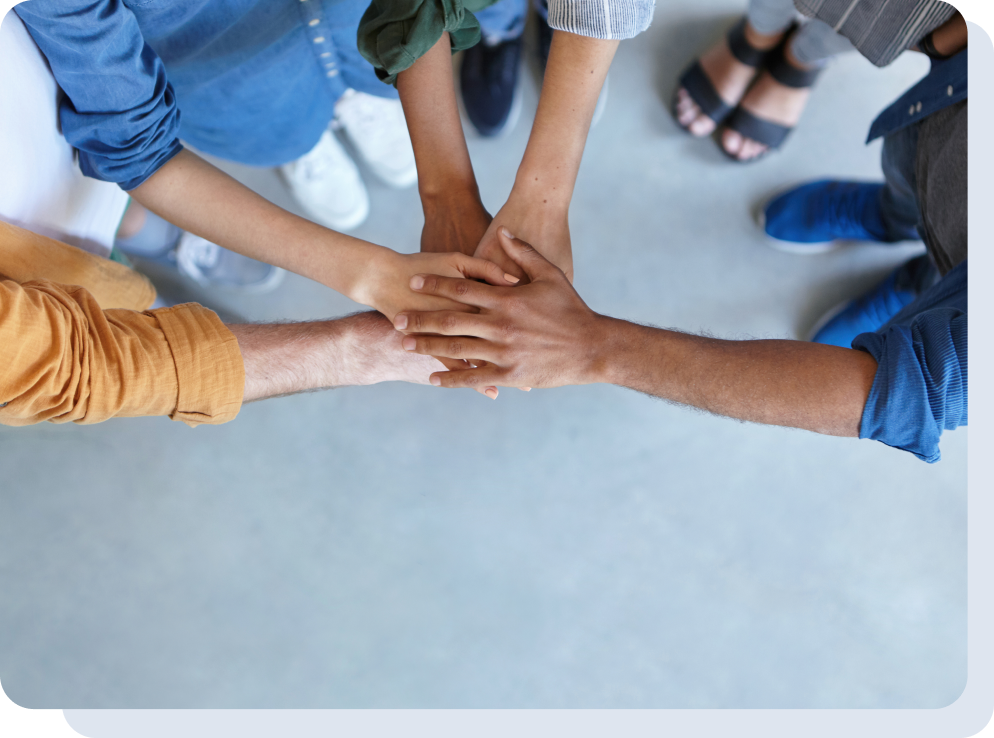 A group of people joining their hands forming a collaborative circle.